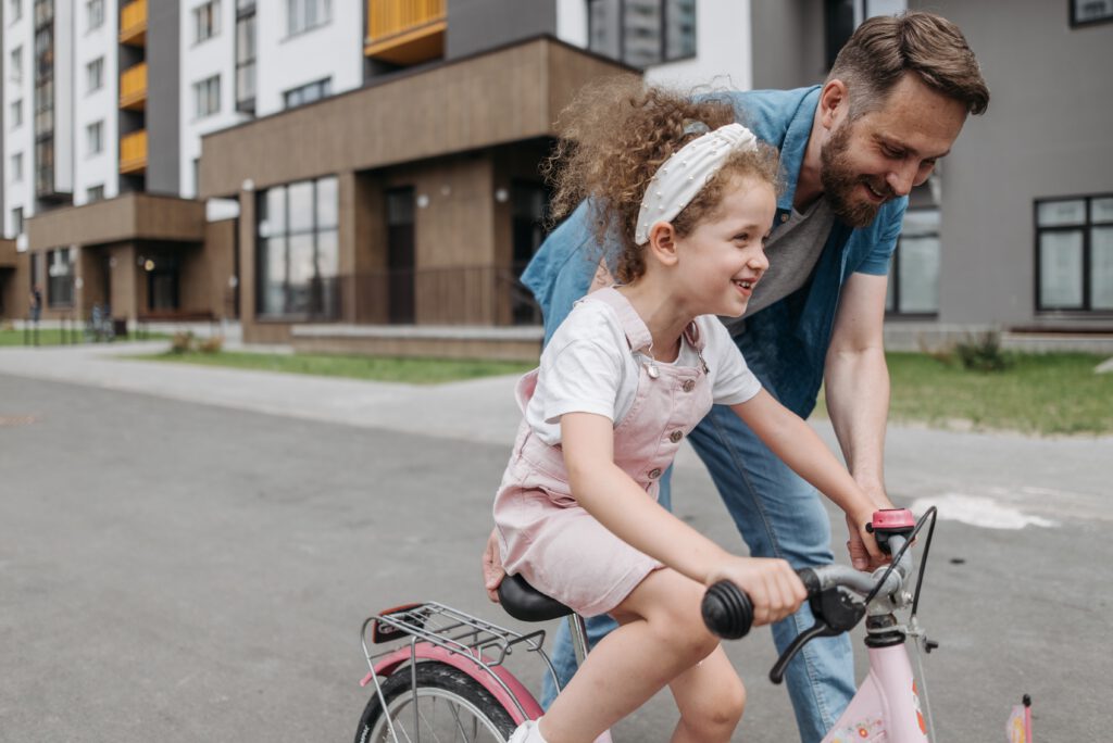 father teaches daughter cycling