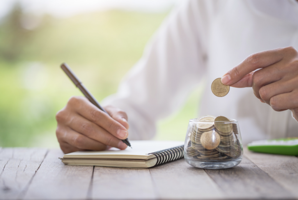 Coins, hand and notebook