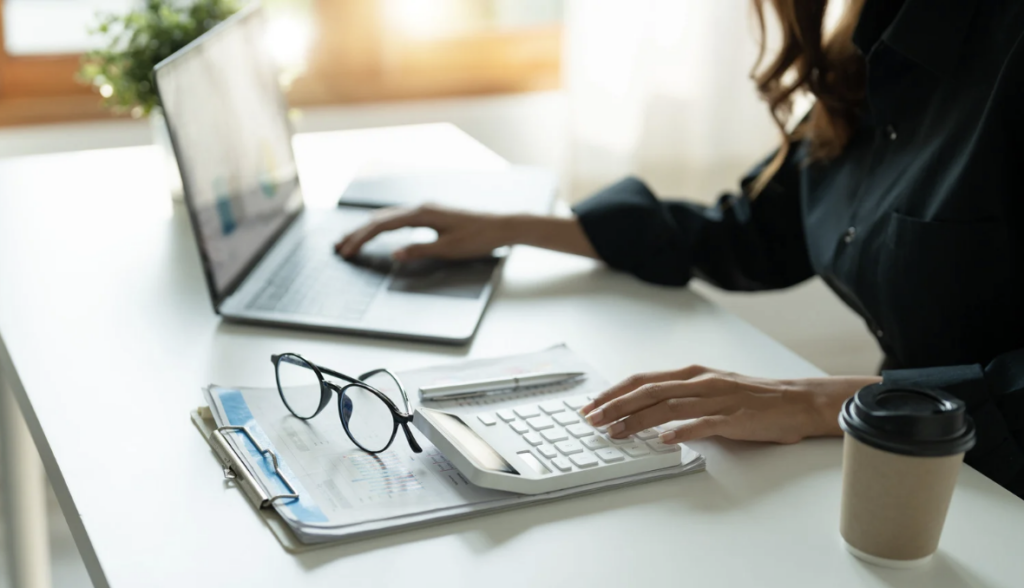 Woman with a computer using a calculator